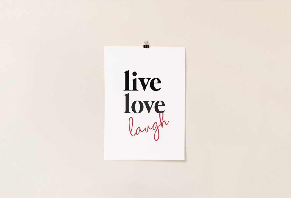 A white poster hanging on the wall with the words live love laugh 